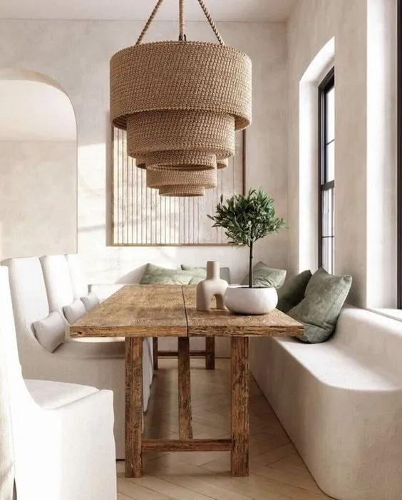 Rustic wooden dining table under a layered rattan pendant light