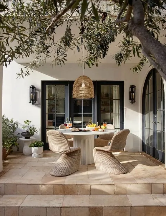 Mediterranean terrace with woven chairs under an olive tree
